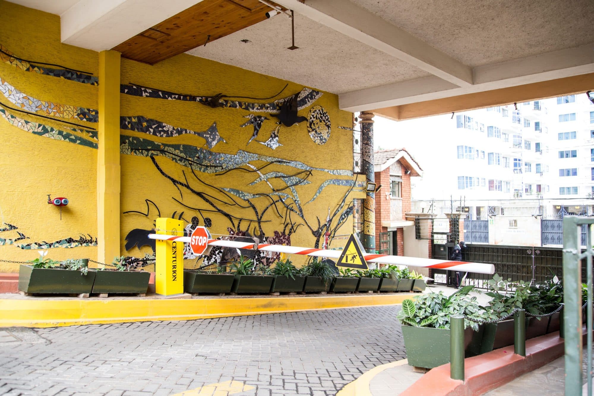 The mosaic mural and planted beds at the Njema Court gate