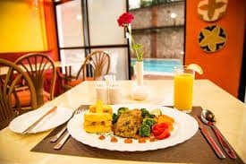 Breakfast with fresh orange juice beside the pool window at Sunflower